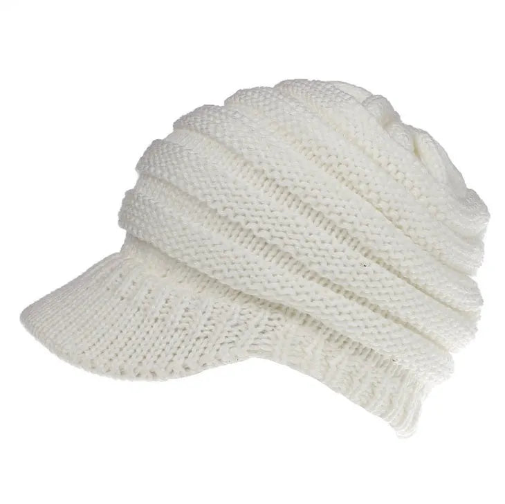 Woman wearing a soft knitted beanie with a ponytail pulled through the hole at the back.