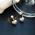 Korean style women's heart shaped stud earrings with pearl-like artificial gemstone inlay on a white background.