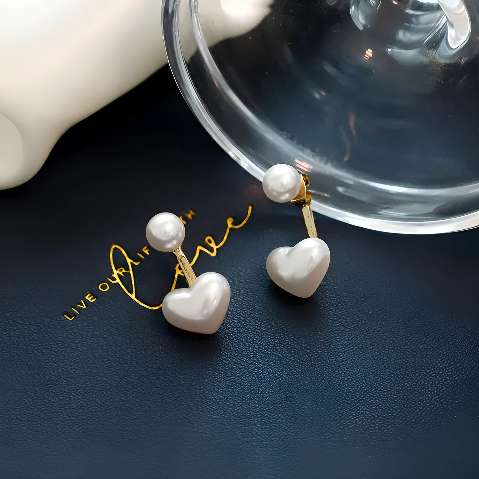 Korean style women's heart shaped stud earrings with pearl-like artificial gemstone inlay on a white background.
