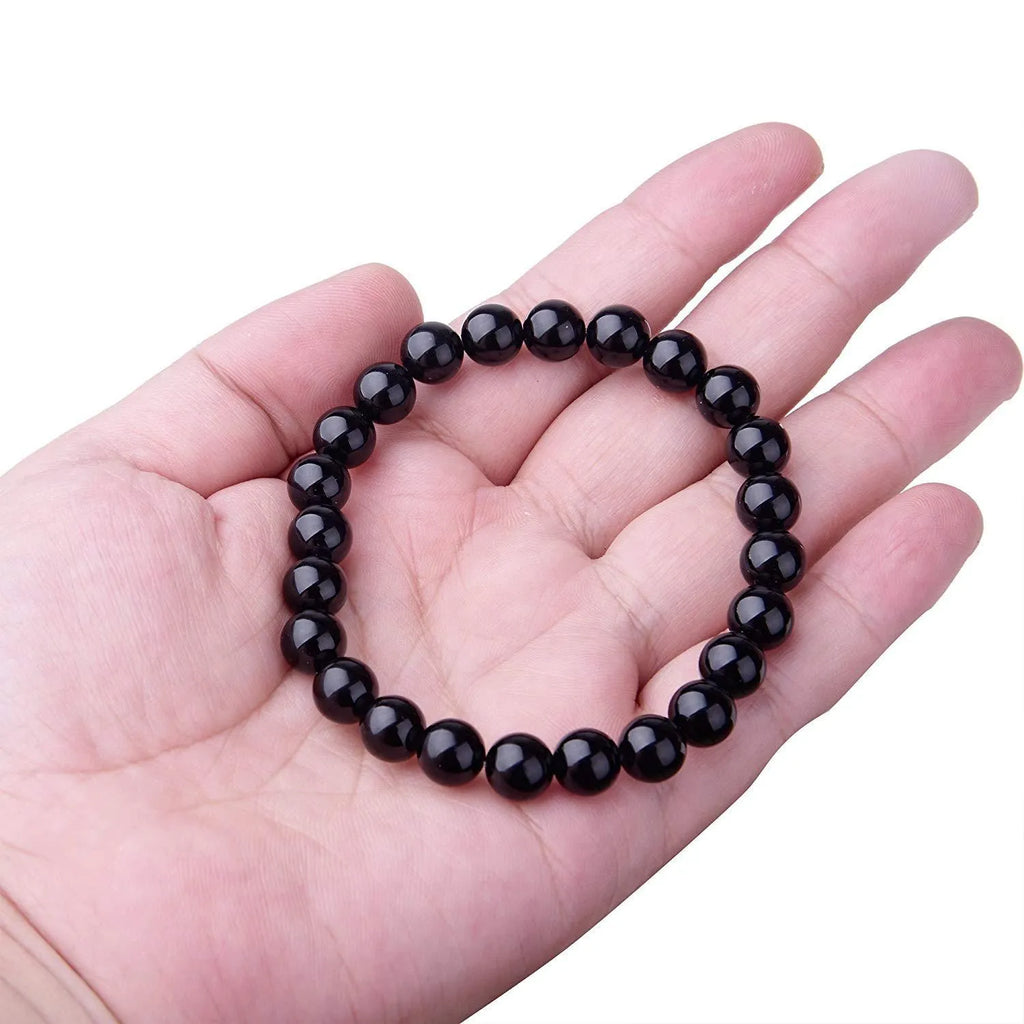 Women's geometric black agate bracelet with 8mm beads on a black elastic cord.