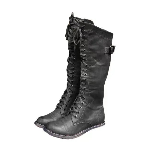 Black chunky heel high leg boots with a round toe and short stout heel on a plain background.