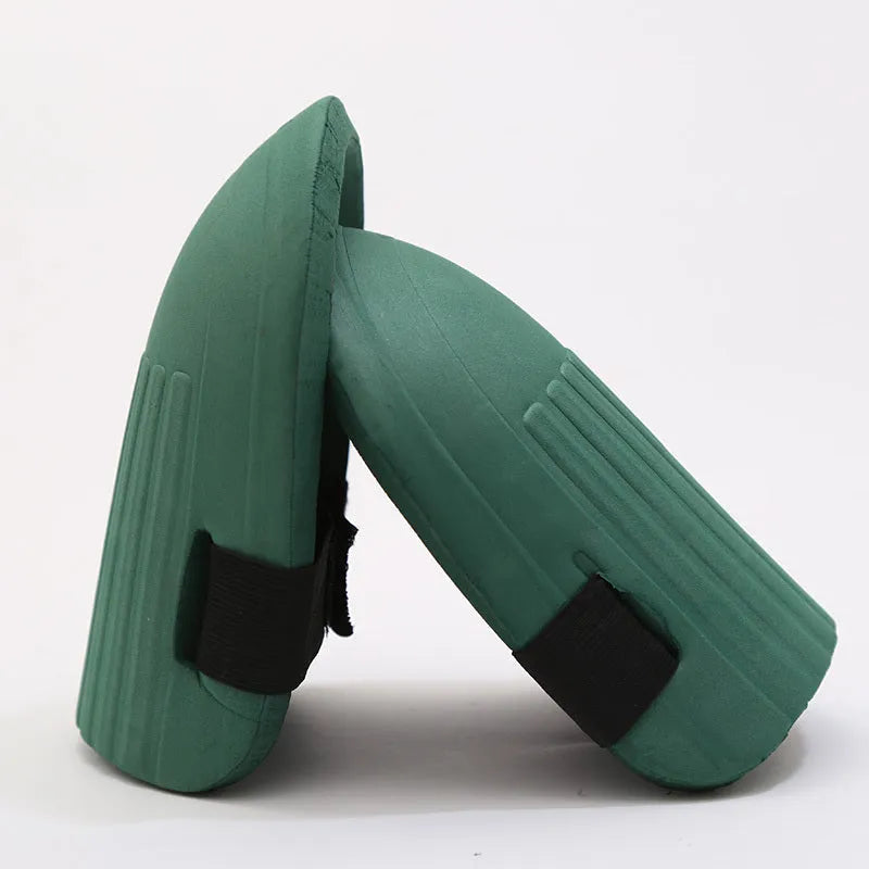 A pair of thick EVA foam kneepads in army green colour on a garden soil background.
