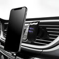 Glossy black car phone holder mounted on vehicle air vent holding smartphone
