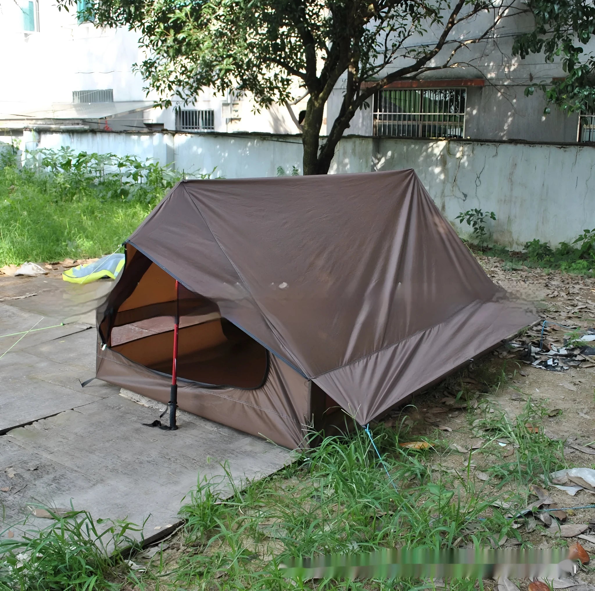 Brown or white A-line cabin tent pitched with trekking poles, showing spacious interior and waterproof fabric construction