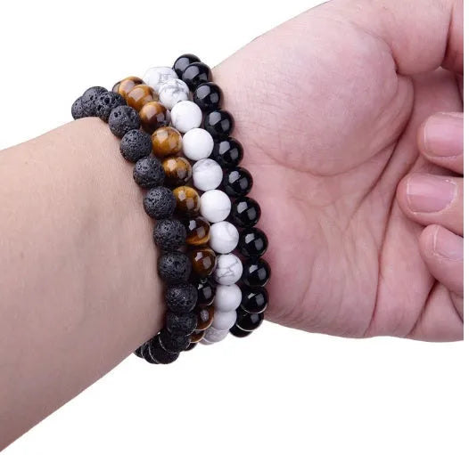 Women's geometric black agate bracelet with 8mm beads on a black elastic cord.