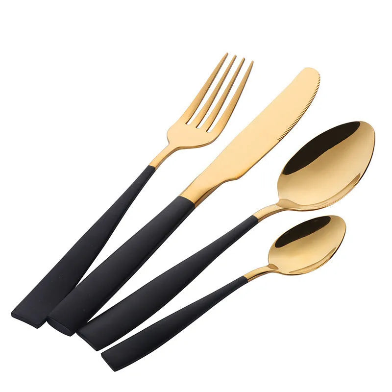 Four-piece stainless steel cutlery set with mirror-polished black finish laid out on a surface
