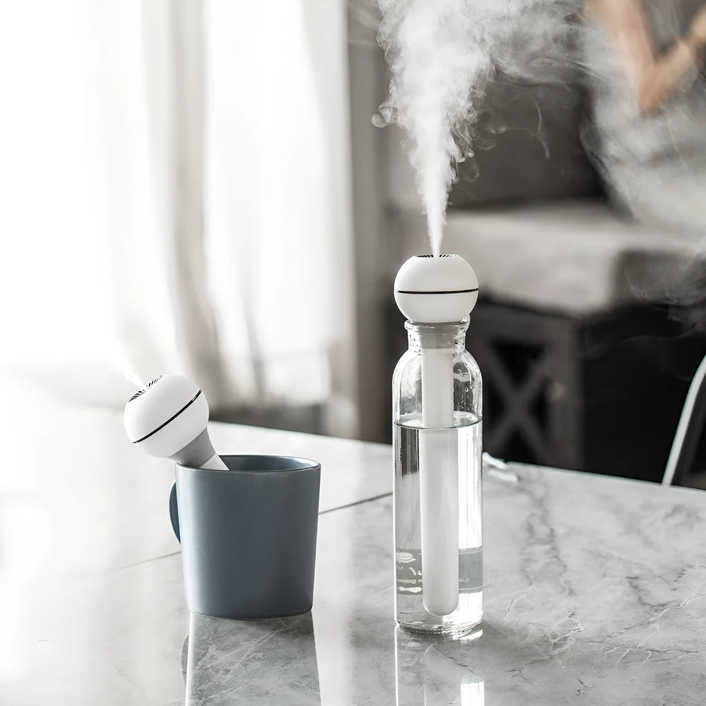 Pink and white columnar magic wand ultrasonic humidifier with USB cable.