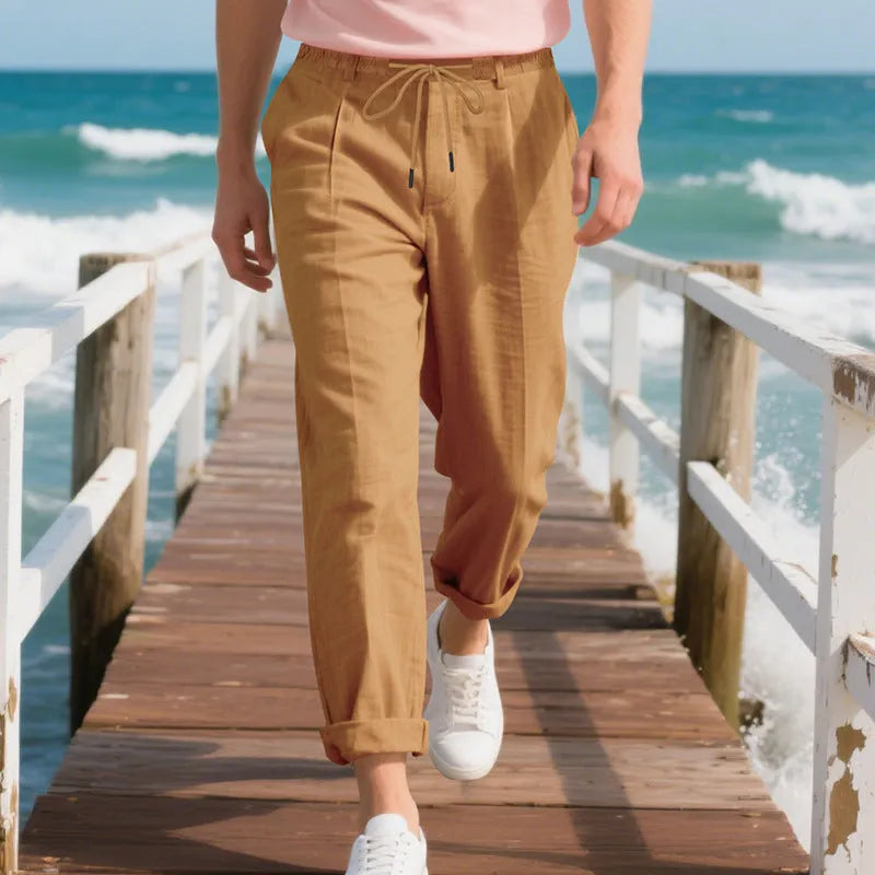 Men's loose-fit straight-leg linen trousers in light khaki colour with a drawstring waist.