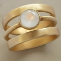 Gold geometric ring with hollow design and white chalcedony inlay on hand