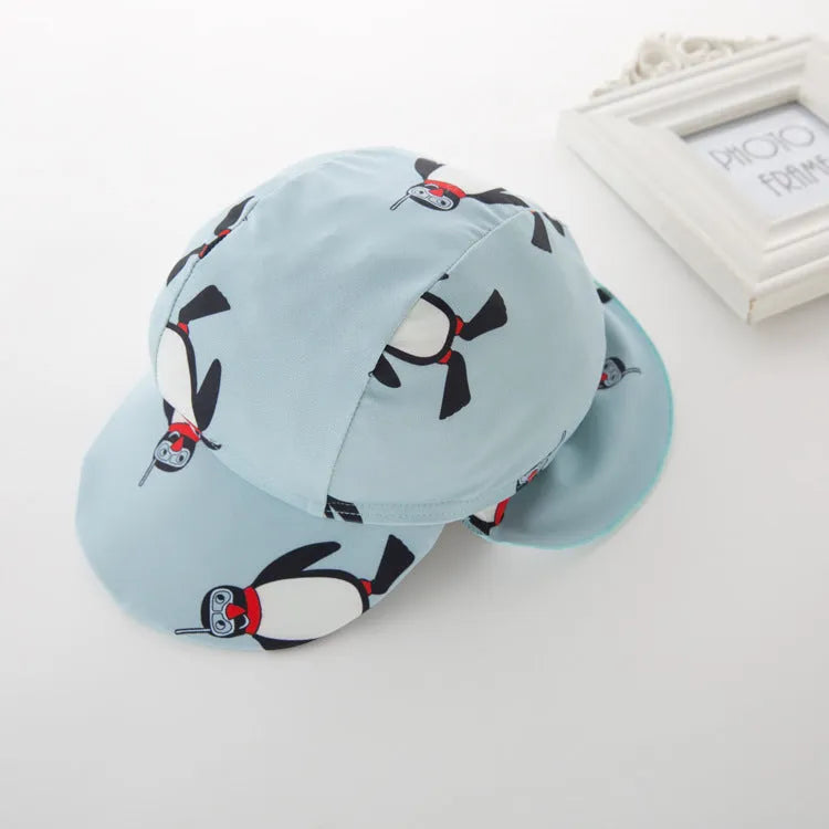 Boys' penguin print long sleeve swim top and matching swimming cap set on a hanger.