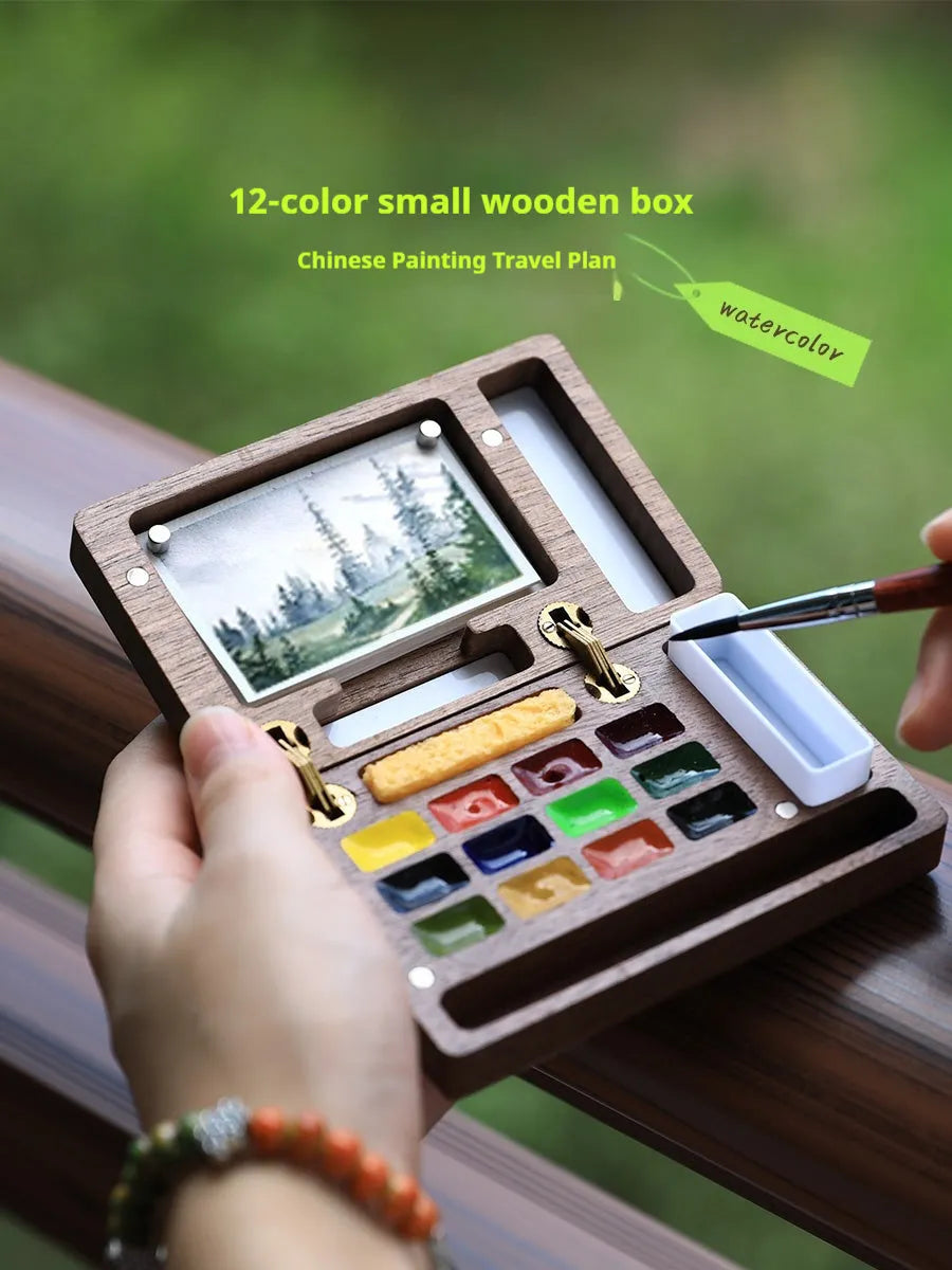 Mini wooden watercolour paint box with pigment suit inside, closed lid showing walnut-colour finish