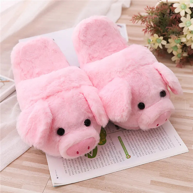 Pink pig-shaped plush slippers for adults on a white background.