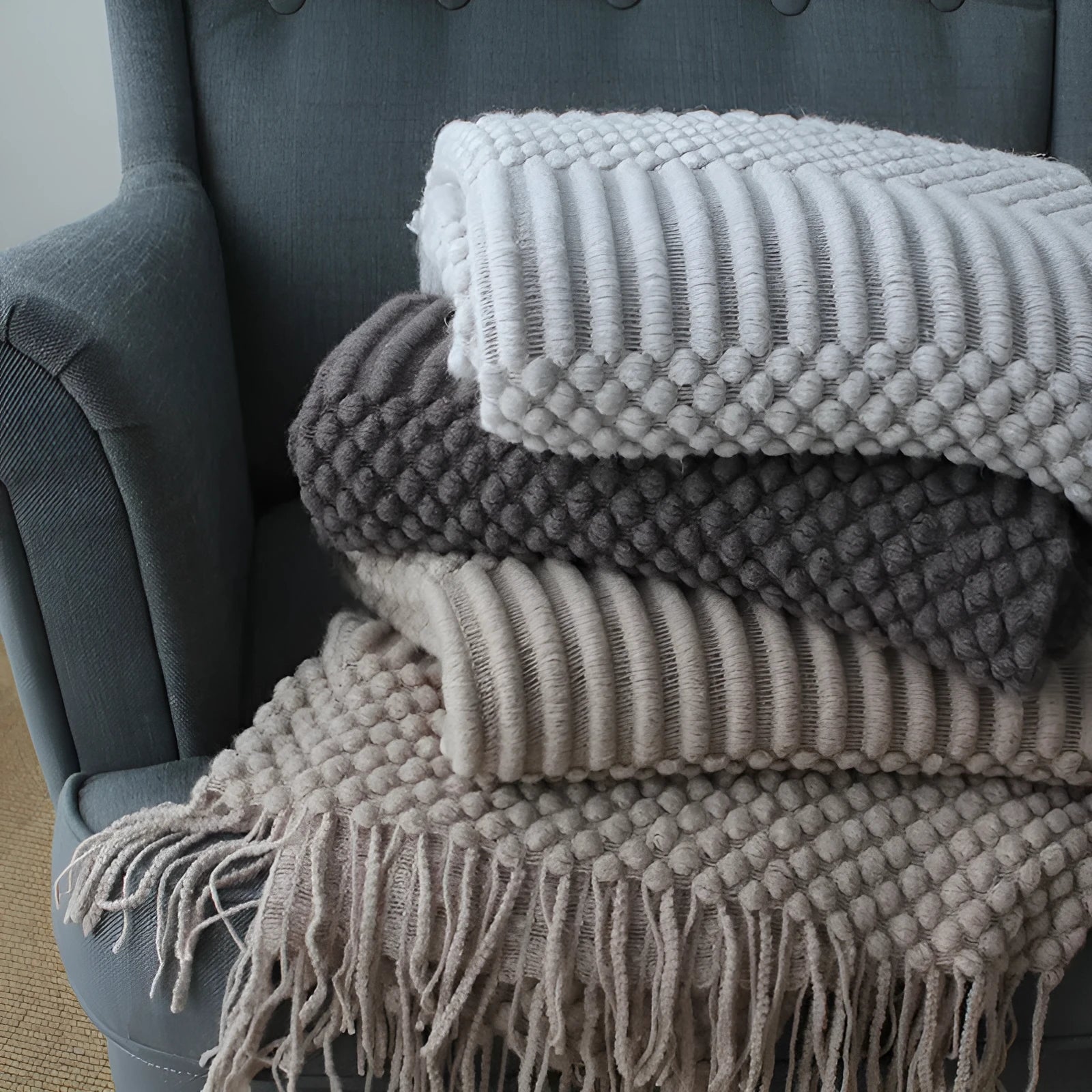Small light grey polyester nap blanket folded, showing its 127cm by 170cm size.