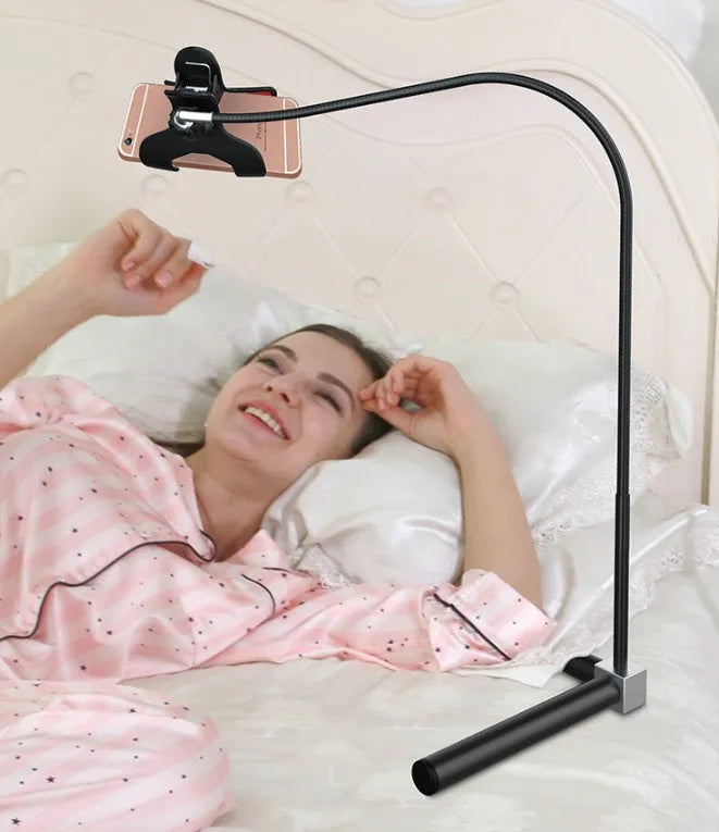 Black bedside mobile phone holder with universal clip and adjustable overhead support shelf mounted on bed frame