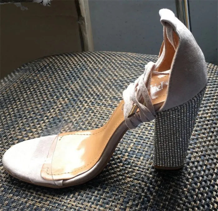 Black and gold women's plastic high heels with a pointed toe and stiletto heel.