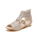 Women's beige flat sandals with back zip closure and low wedge heel.