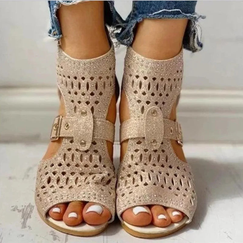 Women's beige flat sandals with back zip closure and low wedge heel.
