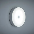Compact beige motion sensing LED night light with USB charging port and adhesive backing