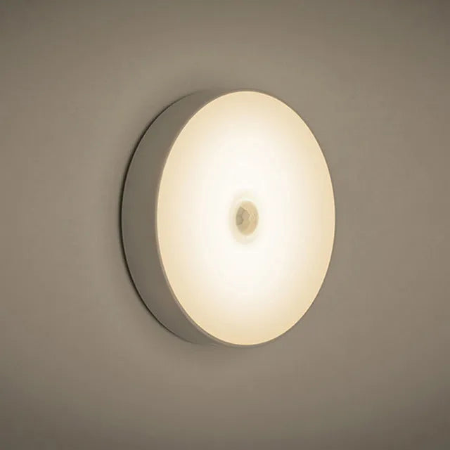 Compact beige motion sensing LED night light with USB charging port and adhesive backing