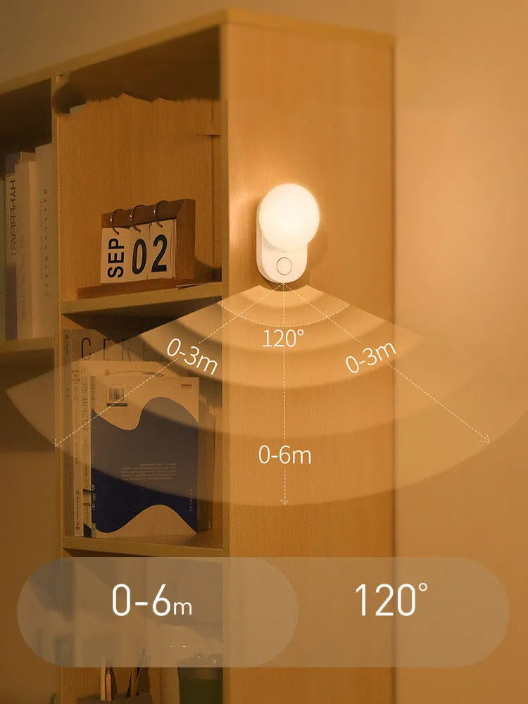 White Baseus rechargeable motion sensor night light with LED glow, shown on a bedside table.