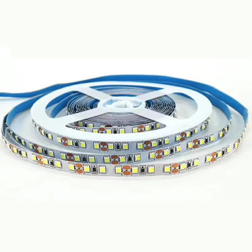 Close-up of a flexible white LED light strip with many small LEDs, coiled on a counter.