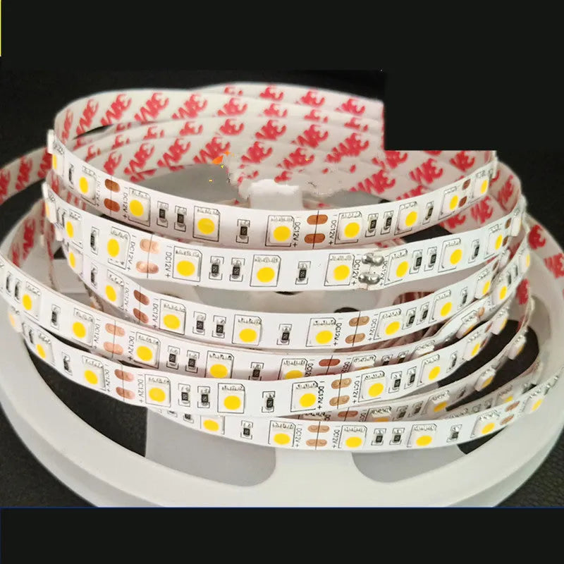Close-up of a flexible white LED light strip with many small LEDs, coiled on a counter.