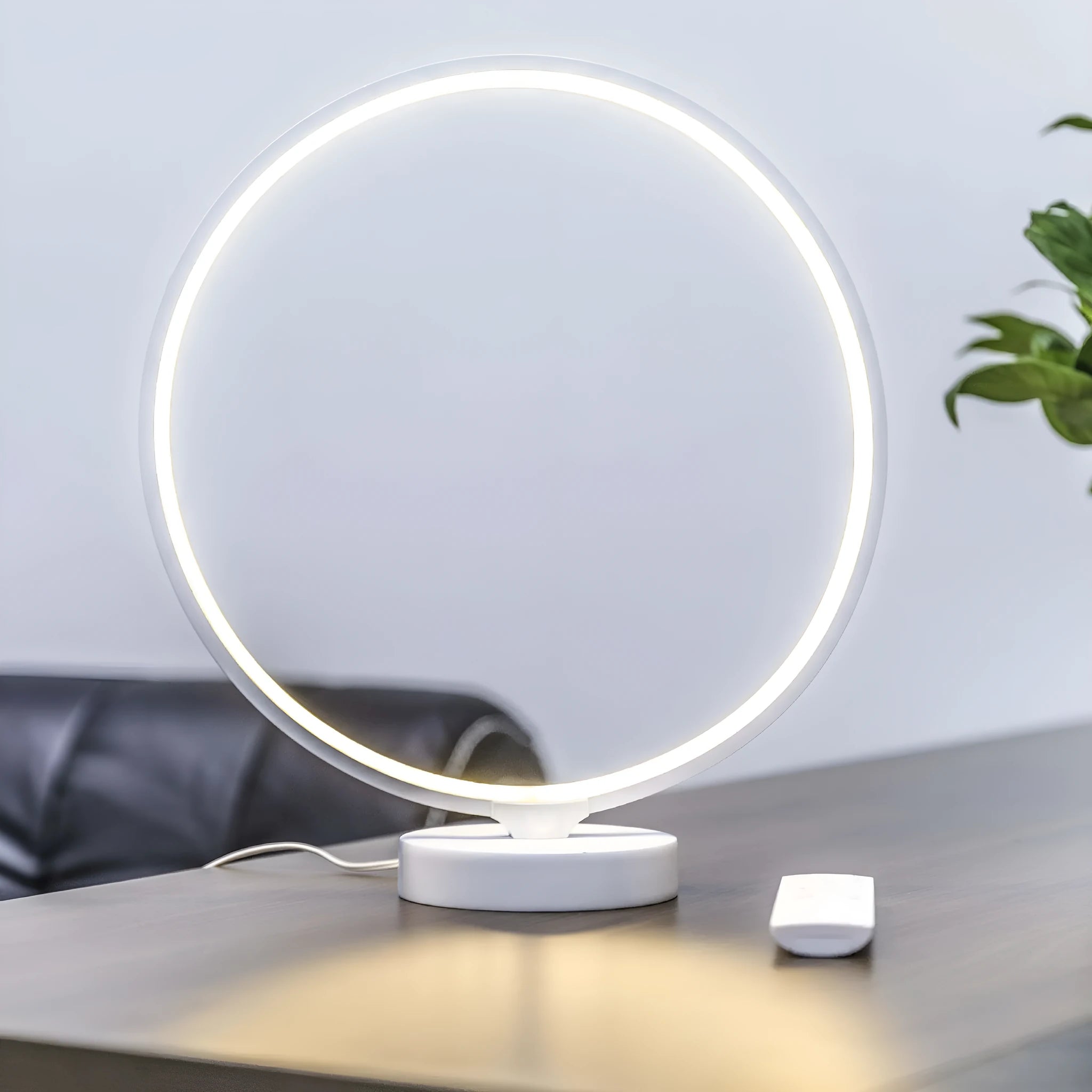 White Full Moon shaped LED table mood lamp with remote control on a wooden surface.