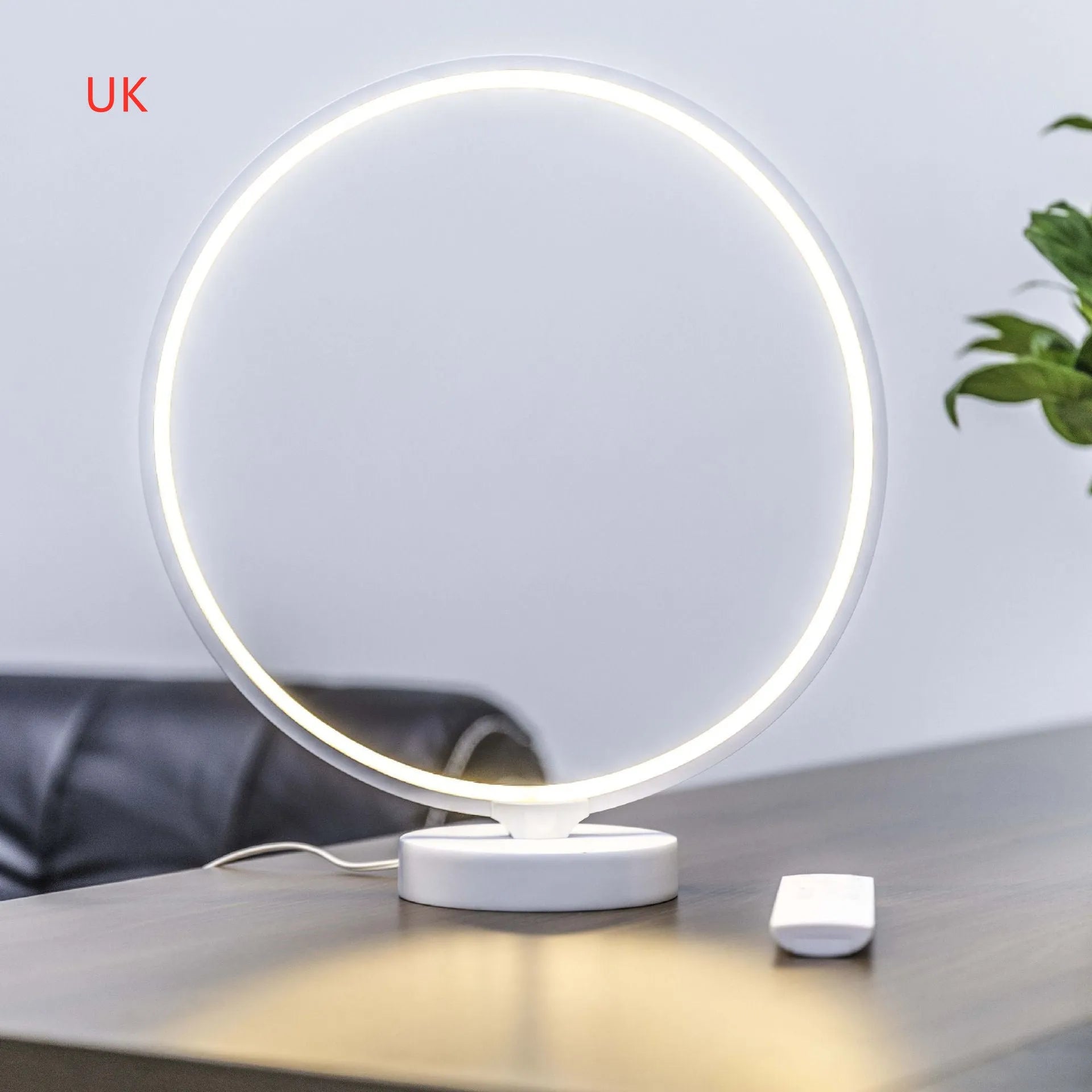 White Full Moon shaped LED table mood lamp with remote control on a wooden surface.