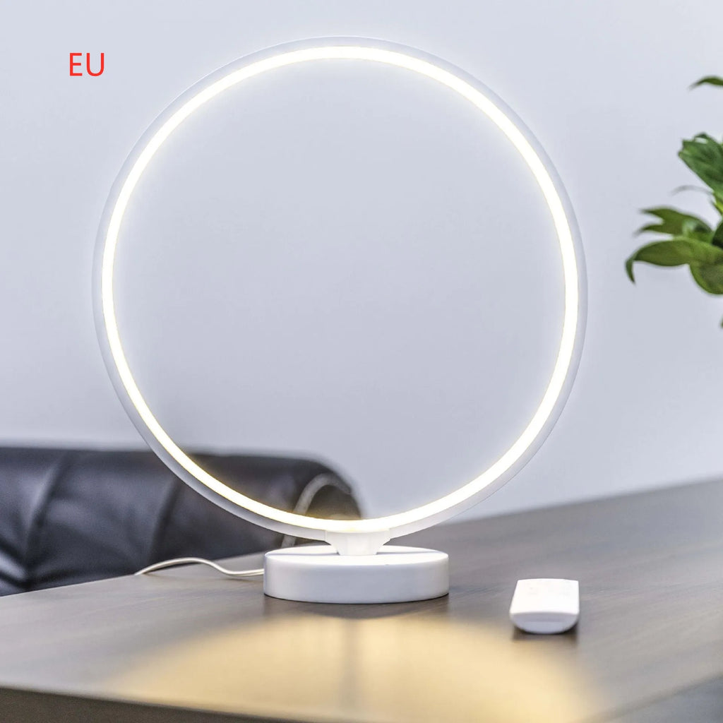 White Full Moon shaped LED table mood lamp with remote control on a wooden surface.