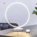 White Full Moon shaped LED table mood lamp with remote control on a wooden surface.