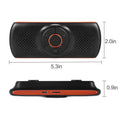 Orange Bluetooth car hands-free speaker unit mounted on a car sun visor