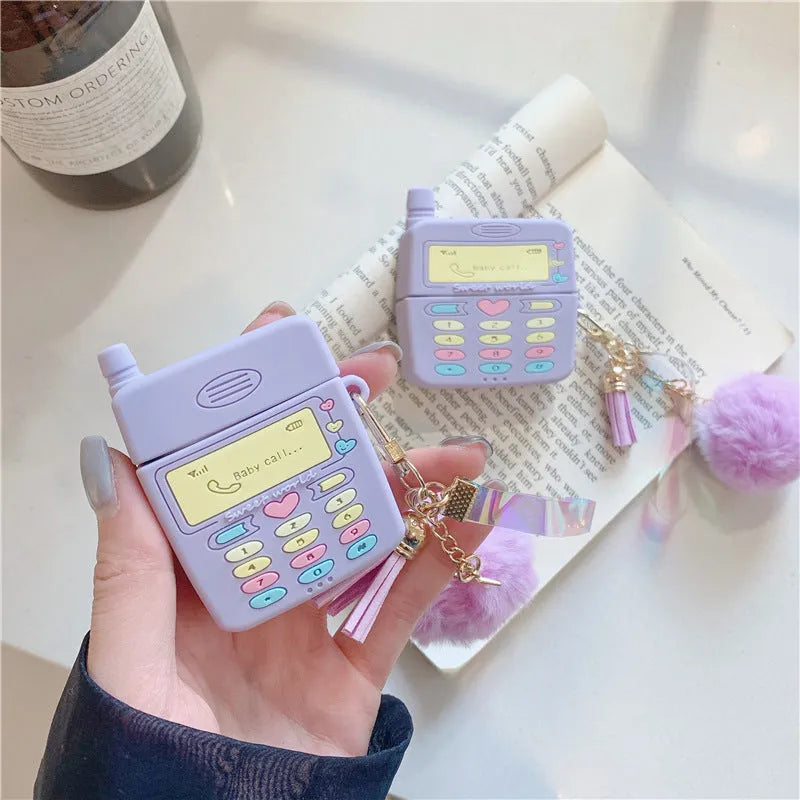 Purple silicone clamshell case for Apple AirPods with a white fur ball pendant attached.