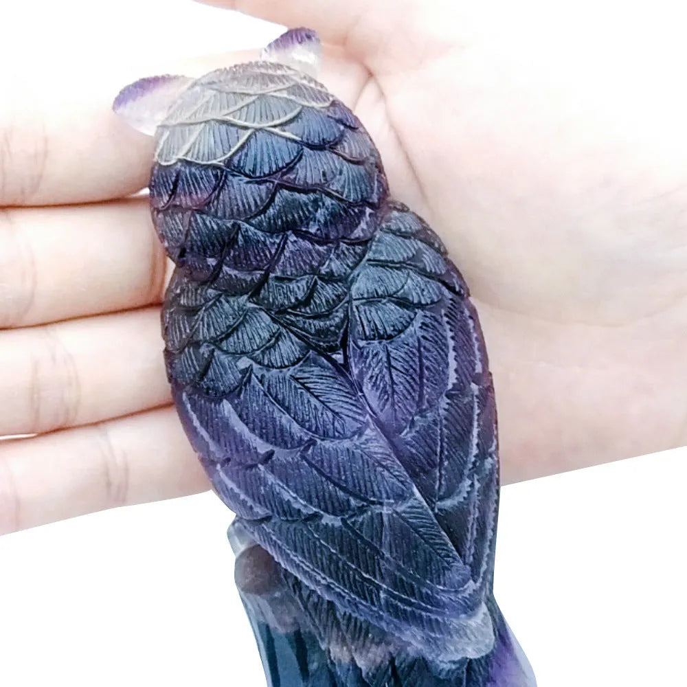 Purple fluorite carved owl statue on white background showing detailed hand carving