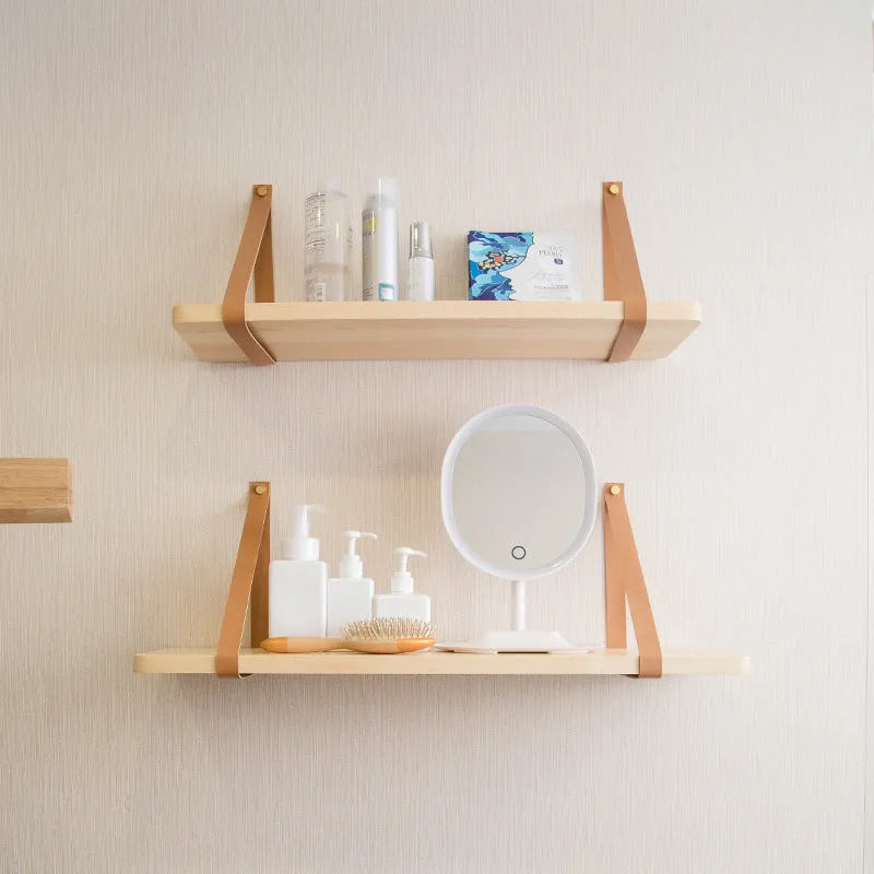 Pine wood wall-mounted storage shelf in Nordic style for organising books and remote controls.