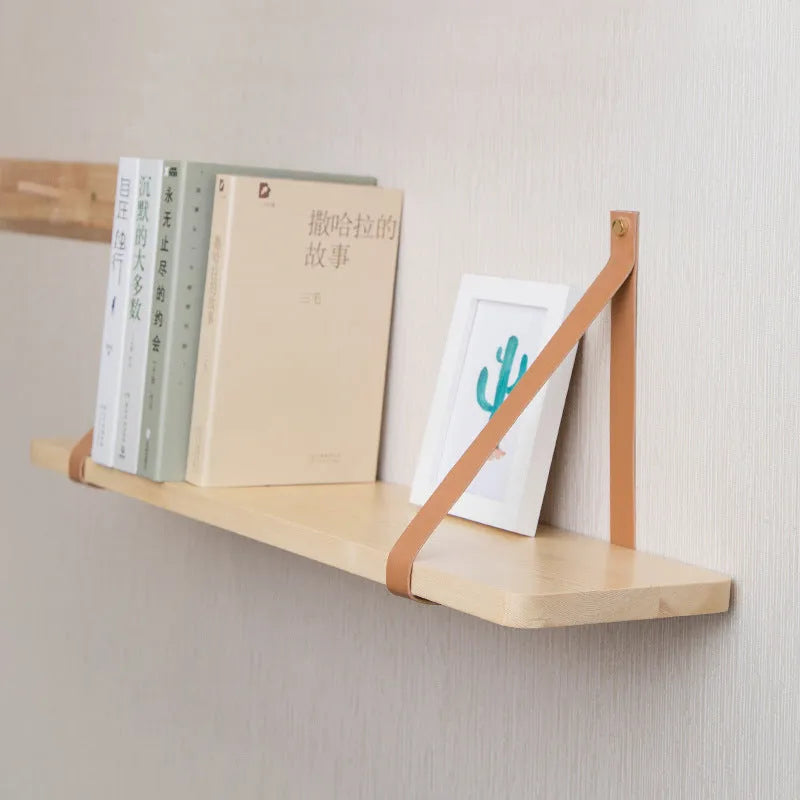 Pine wood wall-mounted storage shelf in Nordic style for organising books and remote controls.
