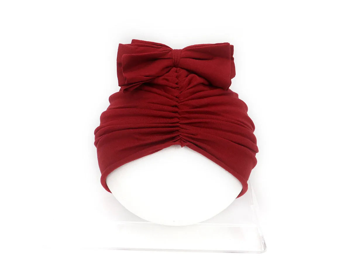 Soft knitted acrylic turban hat for baby girls, shown in a pink colour, fits head size 35-48cm.