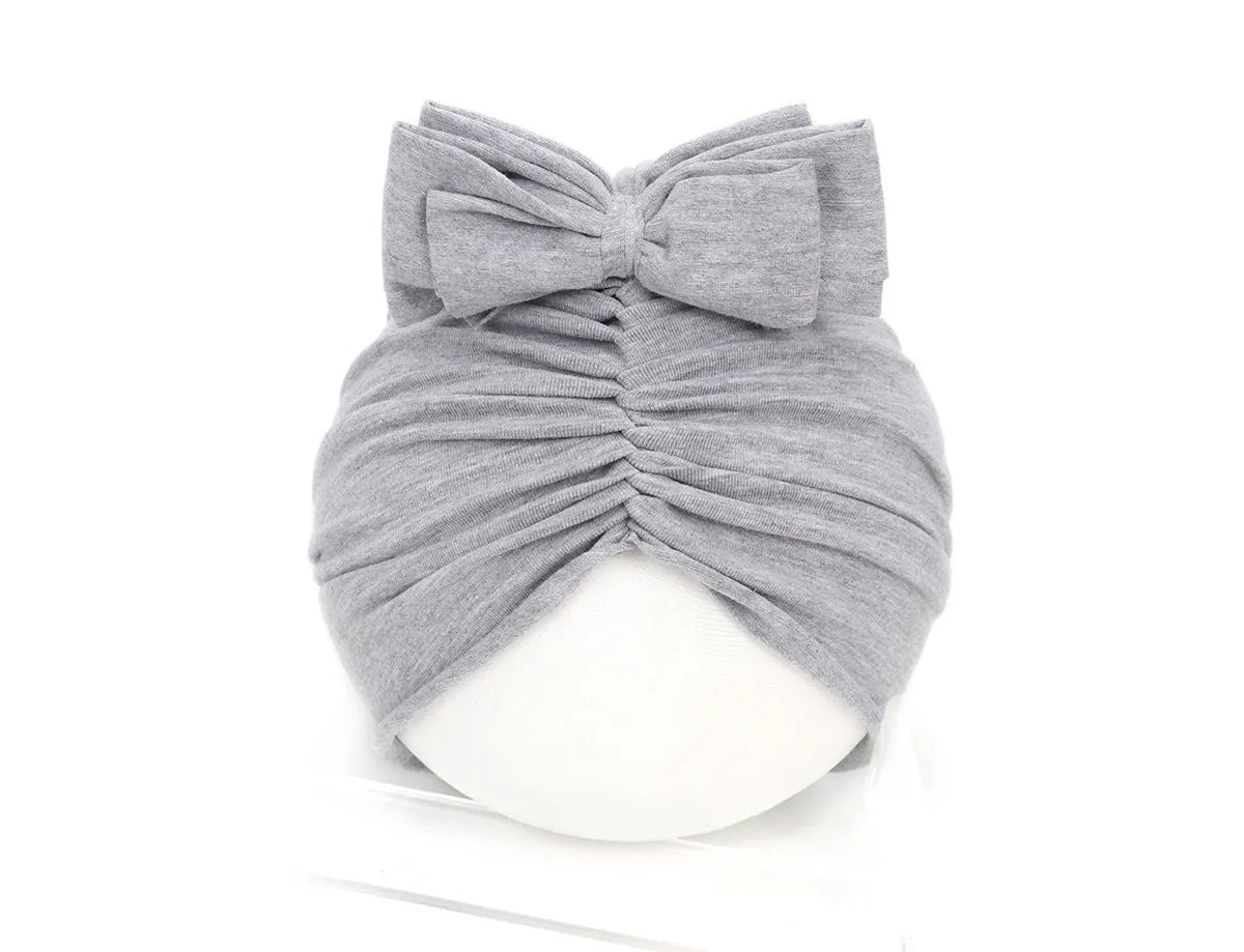 Soft knitted acrylic turban hat for baby girls, shown in a pink colour, fits head size 35-48cm.