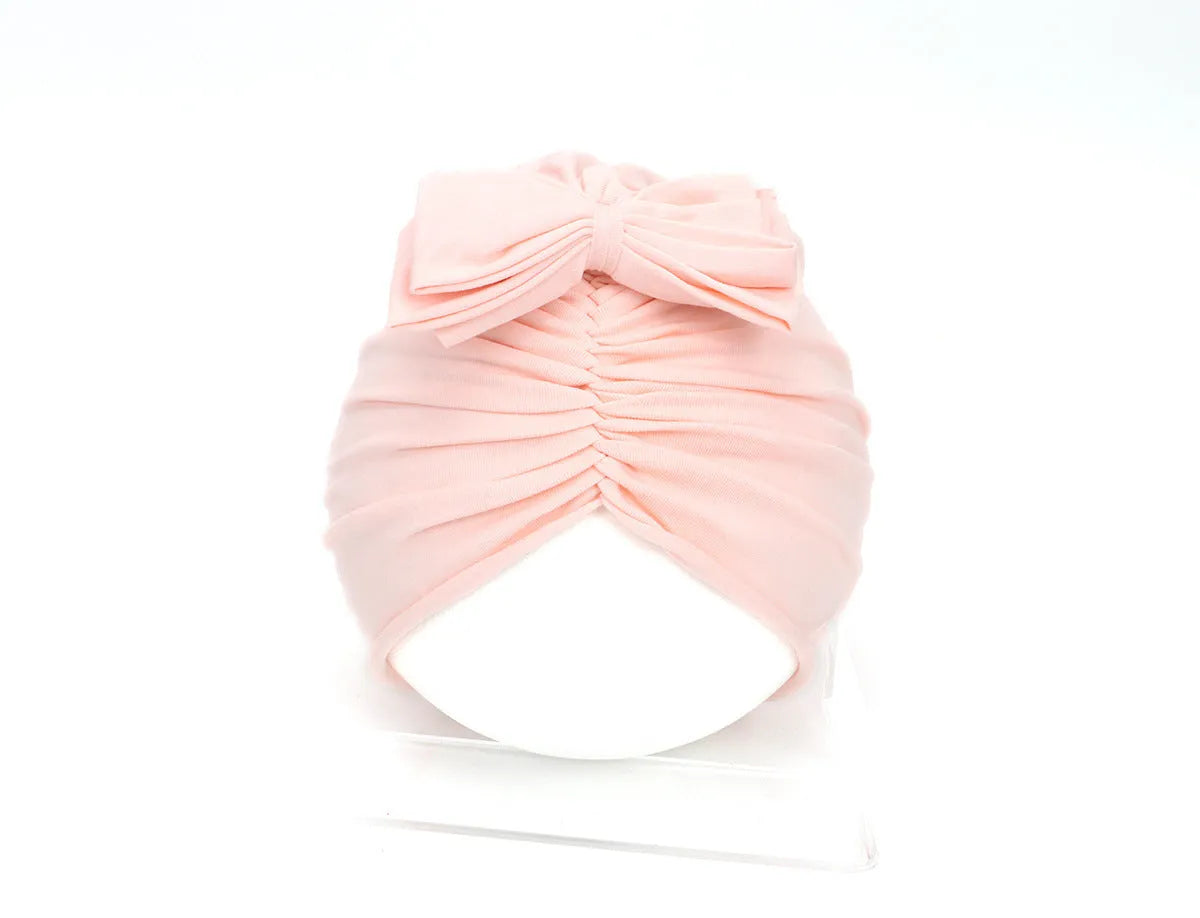 Soft knitted acrylic turban hat for baby girls, shown in a pink colour, fits head size 35-48cm.
