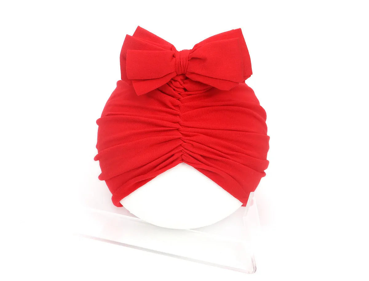 Soft knitted acrylic turban hat for baby girls, shown in a pink colour, fits head size 35-48cm.