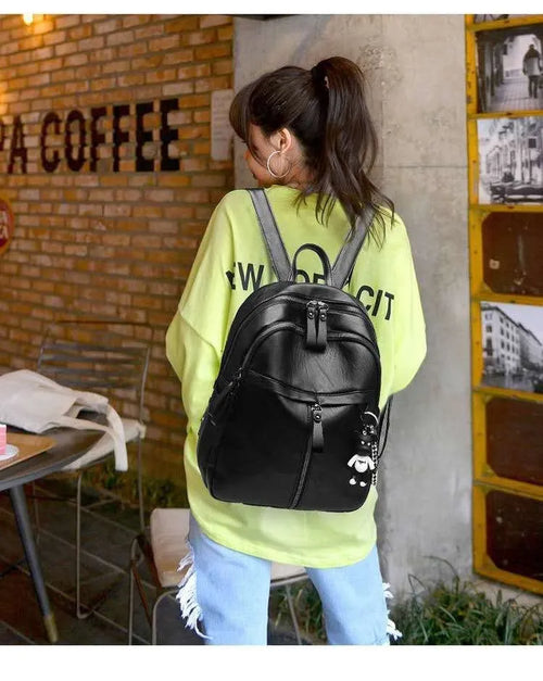Black soft surface PU leather backpack with double straps showing ID compartment and zipper opening
