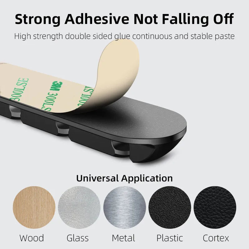 Black soft plastic desktop magnetic charging cable organizer on a wooden desk.