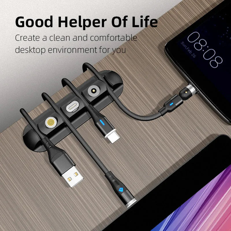 Black soft plastic desktop magnetic charging cable organizer on a wooden desk.