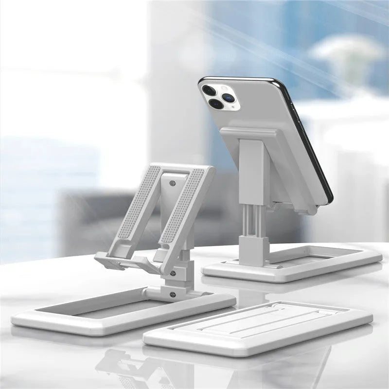 Retractable mobile phone desktop stand in black colour, folded and placed on a desk