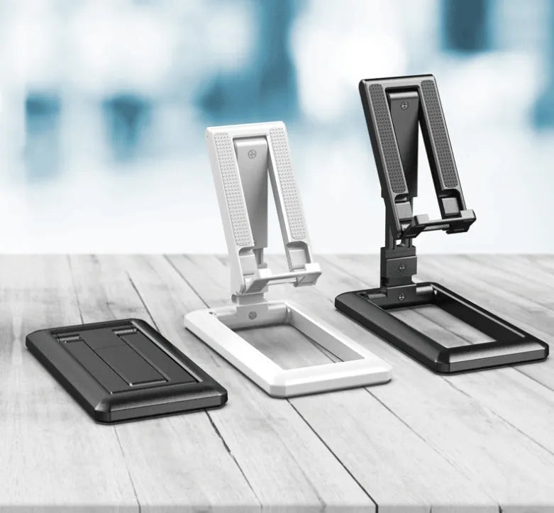 Retractable mobile phone desktop stand in black colour, folded and placed on a desk