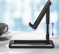 Retractable mobile phone desktop stand in black colour, folded and placed on a desk