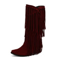 Women's beige suede knee-high boots with tassel, chunky heel, and square toe on a waterproof platform.