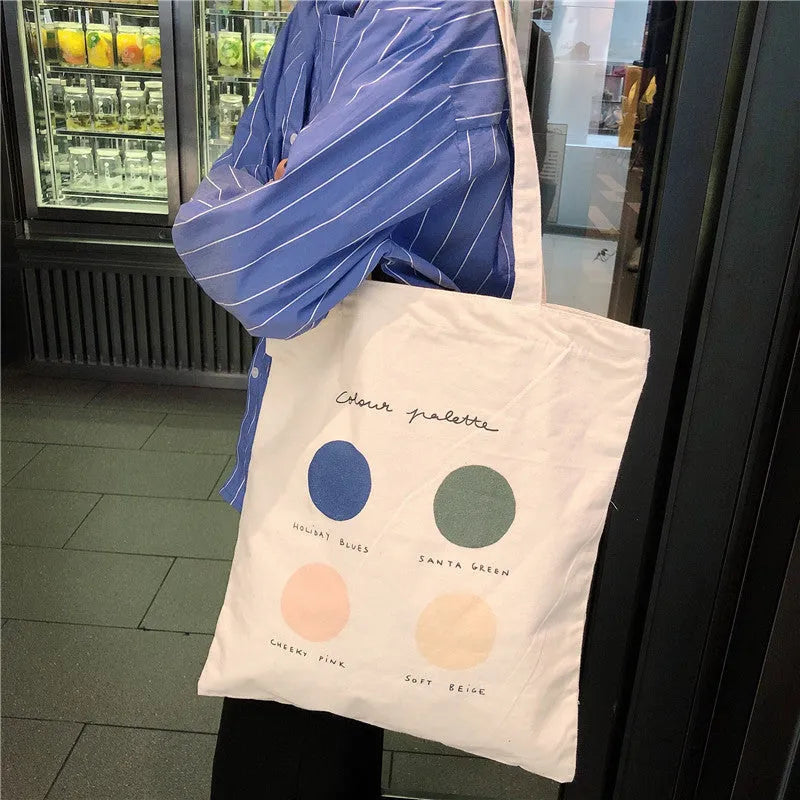 Women's medium canvas tote bag with geometric pattern, zipper closure, and double soft handles in orange or light pink.