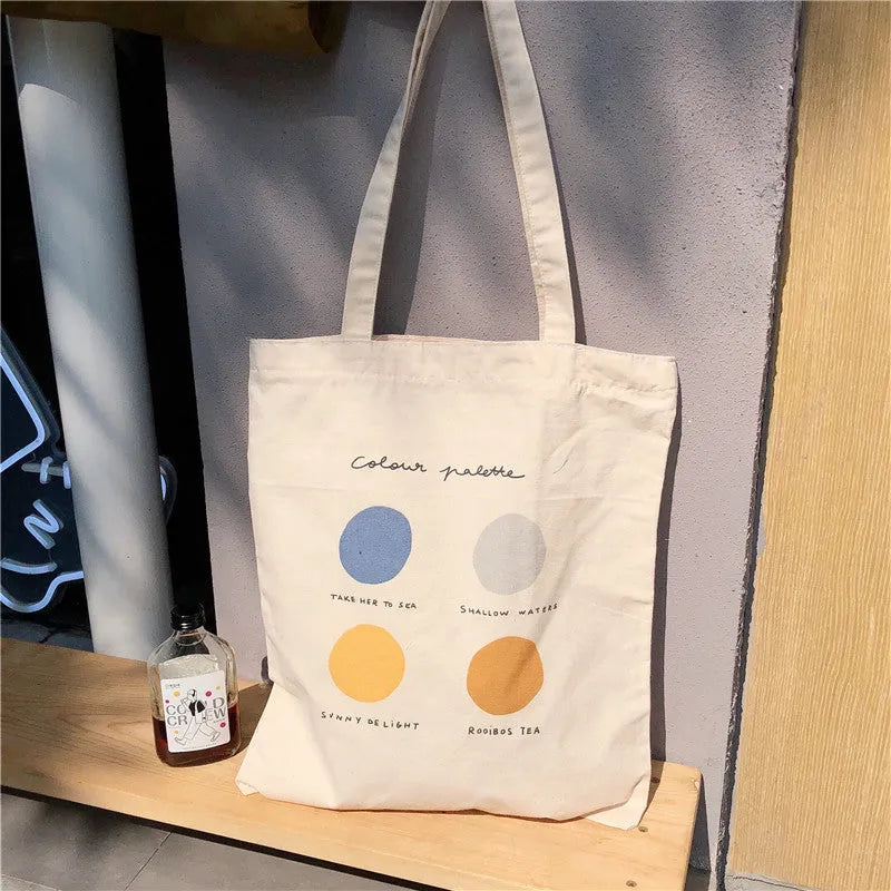 Women's medium canvas tote bag with geometric pattern, zipper closure, and double soft handles in orange or light pink.