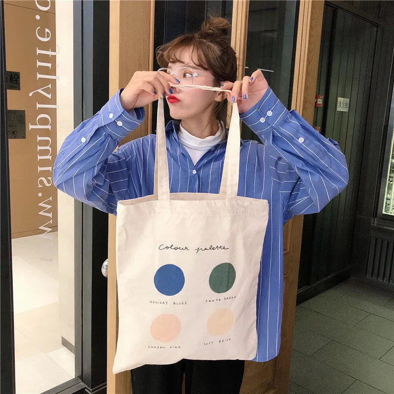 Women's medium canvas tote bag with geometric pattern, zipper closure, and double soft handles in orange or light pink.