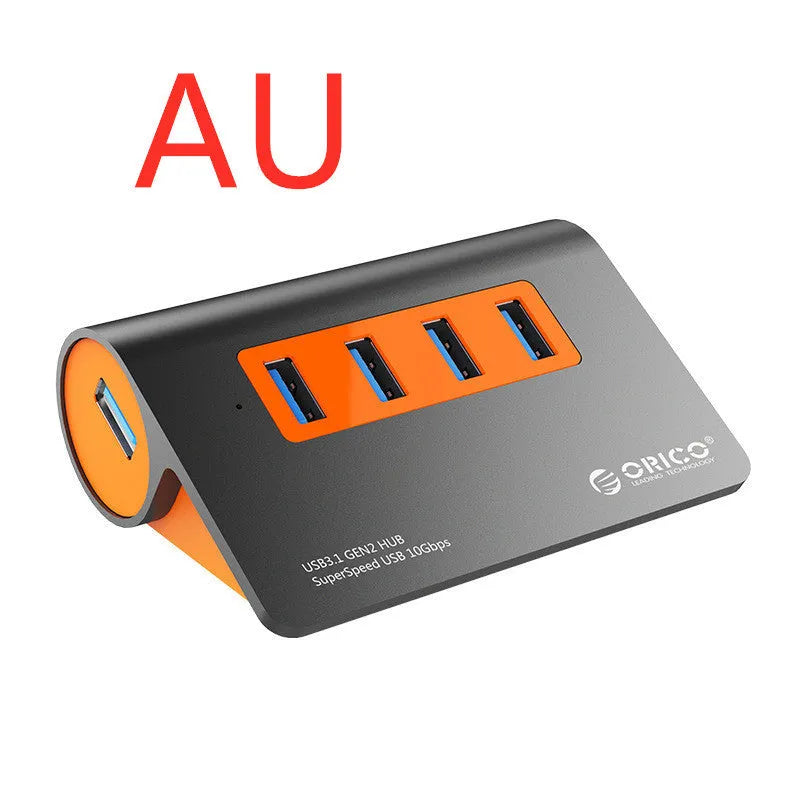 Dark grey aluminium USB hub with orange accents showing four USB 3.1 ports and separate power supply